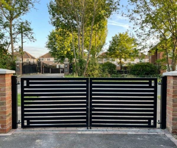 Bespoke electric driveway gates and metal railings installed on a London property by NOVA Steels]'